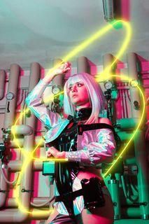 Wide industrial-scene customer shot by @Pinky with glowing neon light trails, fully showing the layered belt setup and hip cutout layout of the costume