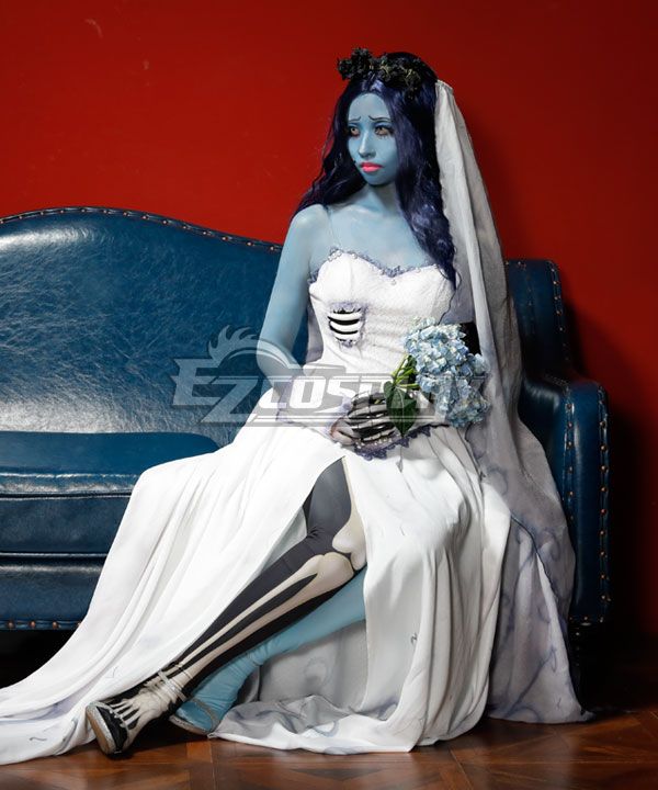 Sitting pose official studio shot on vintage blue leather sofa, split chiffon skirt spread open to show skeleton printed leg detail, lace skeleton gloves holding blue hydrangea bouquet, pearl lace trim on corset hem, long gradient veil drape over sofa armrest