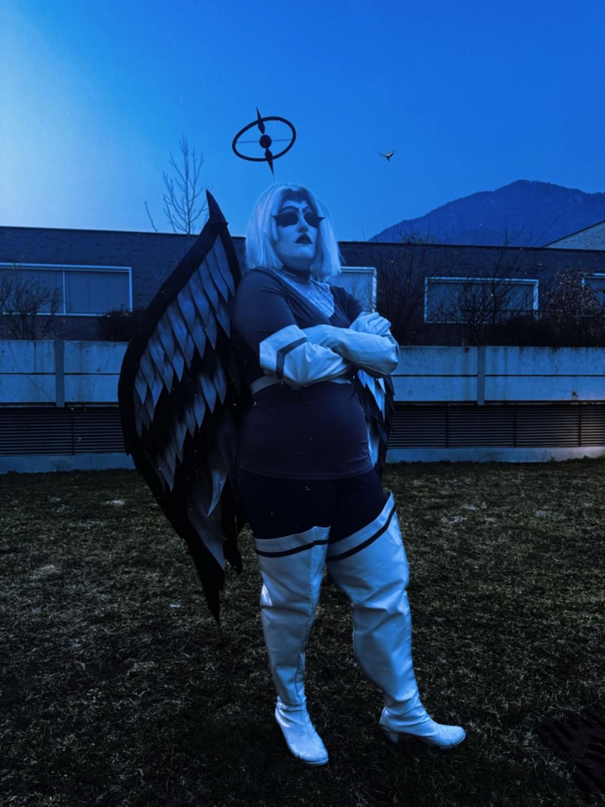 Outdoor dusk themed customer shot by @spgiuly, Lute cosplay with crossed arms, black and grey feather wings, full uniform and white thigh-high boots